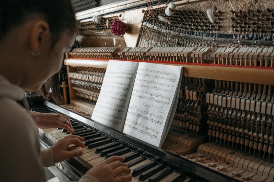 Student practising piano with sheet music